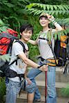 Young couple hiking together in a forest, smiling