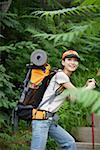 Young woman hiking in a forest, smiling