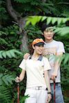 Young couple holding hiking pole, smiling