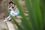 Young couple sitting on steps, smiling