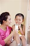 Mother giving glass of milk to son