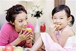 Mother and daughter eating fruit