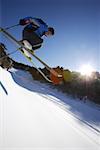 Male skier in mid-air, low angle view