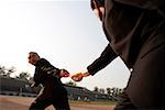 Businessmen exchanging baton in a relay event