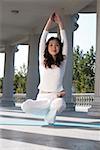 Woman practicing yoga in front of white pillars