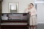 Young woman standing by grand piano