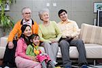 Family sitting together and watching television, smiling