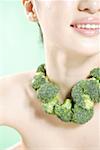 Close-up of woman with broccoli on neck