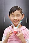 Close-up of a girl holding toy and smiling