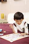 Boy lying on bed and painting