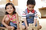 Close-up of boy and girl playing with wooden toy