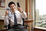 Close-up of a businessman holding toy and reading text message