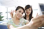 Young women taking self- photograph with mobile phone