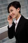 Young businesswoman using mobile phone, smiling