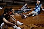 Basketball player relaxing on hardwood floor