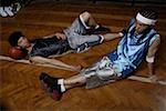 Basketball player relaxing on hardwood floor, elevated view