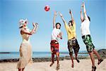 Young people playing ball on beach