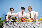 Portrait of a young men sitting by table with fruit