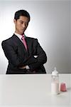 Businessman looking at baby bottle