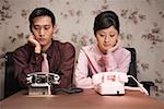 Jeune homme d'affaires et femme assise au bureau avec téléphone