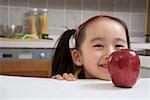 Girl behind red apple