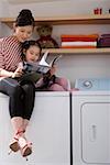 Mom and daughter reading on washer