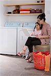 Mom and daughter playing with laptop in washhouse