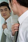 Businessman looking in mirror and smiling