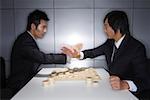Zwei junge Männer und chinesisches Schach kämpfen
