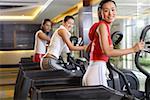 Young men and young women exercising on exercise machine