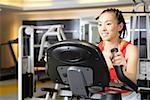 Young woman exercising on exercise bike in gym