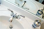 Close-up of a faucet and a soap dispenser on a bathroom sink