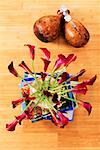 High angle view of flowers in a vase on a stack of books with dried gourds