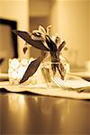 Close-up of a flower vase with a candlestick holder on a dining table