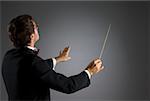 Profil de côté d'un chef d'orchestre de musique effectuant