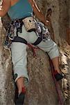 Low angle view of a female rock climber climbing a rock
