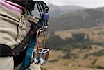 Mid section view of a rock climber carrying rock climbing equipments