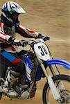 Side profile of a motocross rider riding a motorcycle