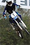 Low angle view of a motocross rider performing a jump on a motorcycle