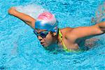 Young woman swimming the butterfly stroke in a swimming pool