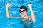 Young man looking excited after achieving success in a swimming pool