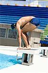 Side profile of a young man taking start from a diving platform