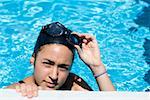 Portrait d'une jeune femme au bord d'une piscine de préhension
