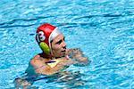 Side profile of a mid adult man playing water polo in a swimming pool