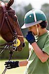 Teenage boy standing with a horse