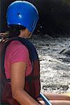 Side profile of a woman rafting in a river