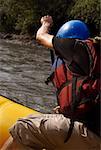 Side profile of a person rafting in a river