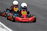 Two people go-carting on a motor racing track