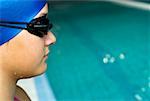 Close-up of a teenage girl wearing a swimming cap and swimming goggles