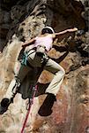 Rear view of a female rock climber scaling a rock face